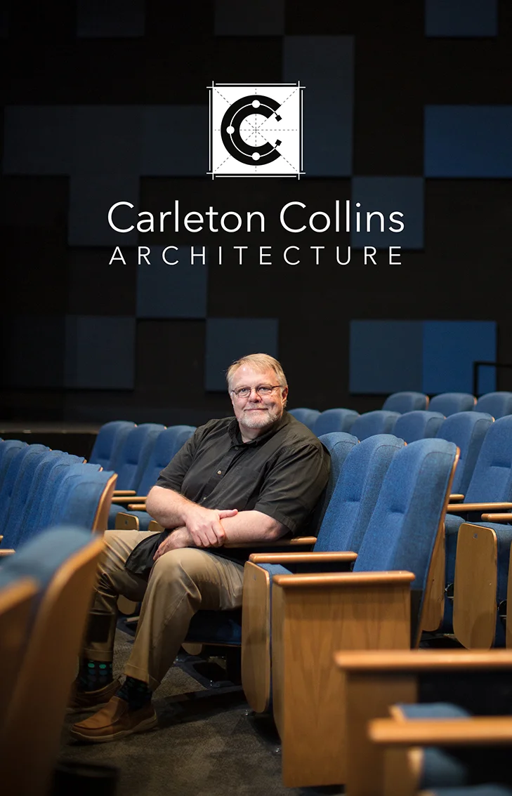 Photo of Carleton Collins sitting in a theater seat of a theater he designed.